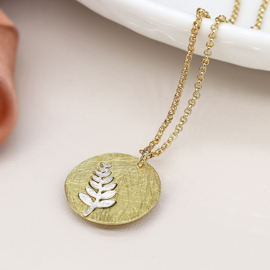 Faux gold scratched disc necklace with silver plated fern inlay