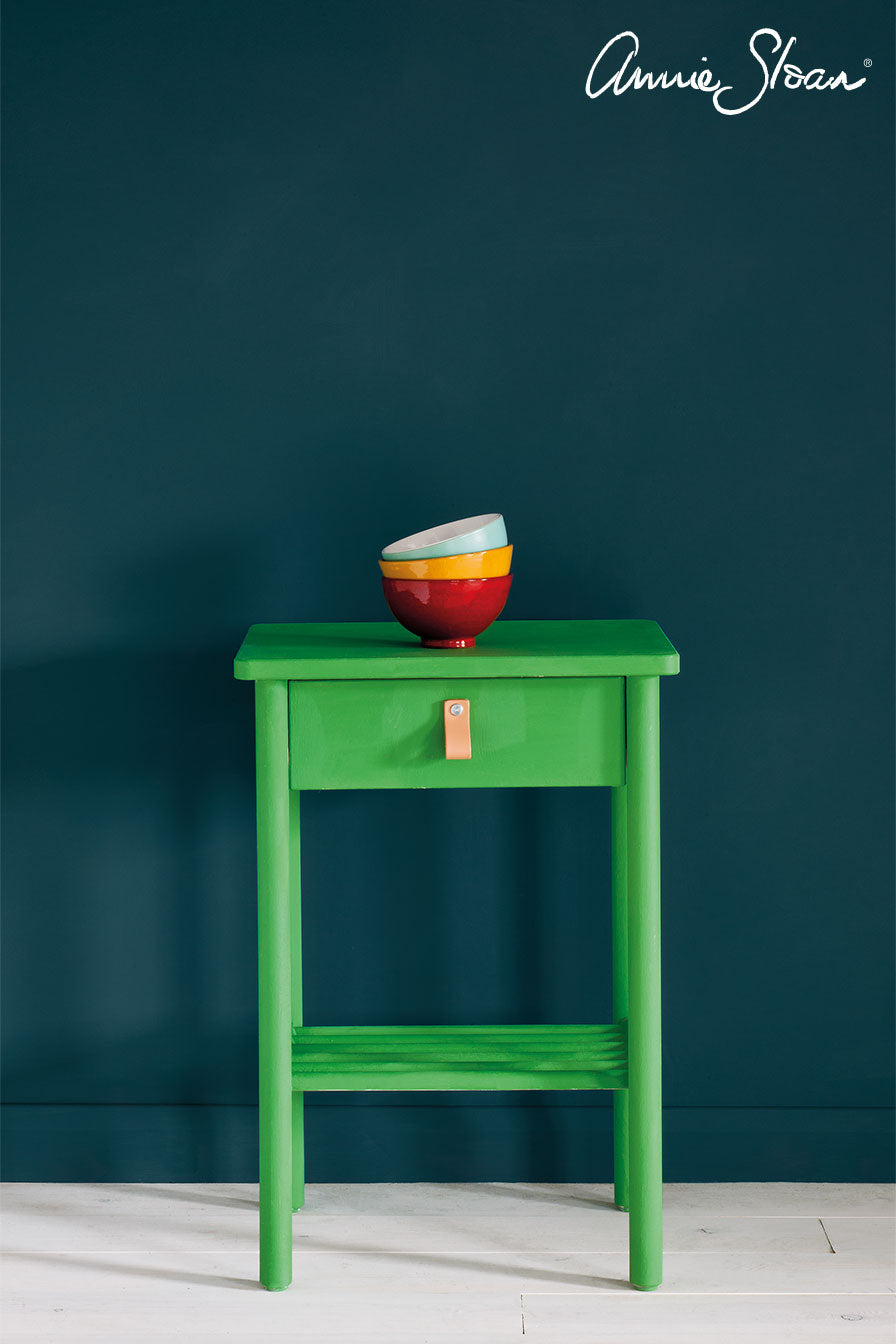 A side table painted with Annie Sloan Antibes Green Chalk Paint against a wall painted with Aubusson wall paint