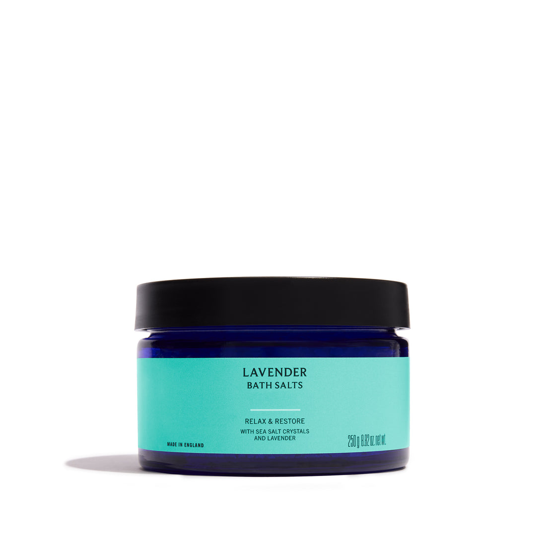 A jar of Lavender Bath Salts in a dark blue jar with a black lid and a light turquoise label, set against a plain white background.