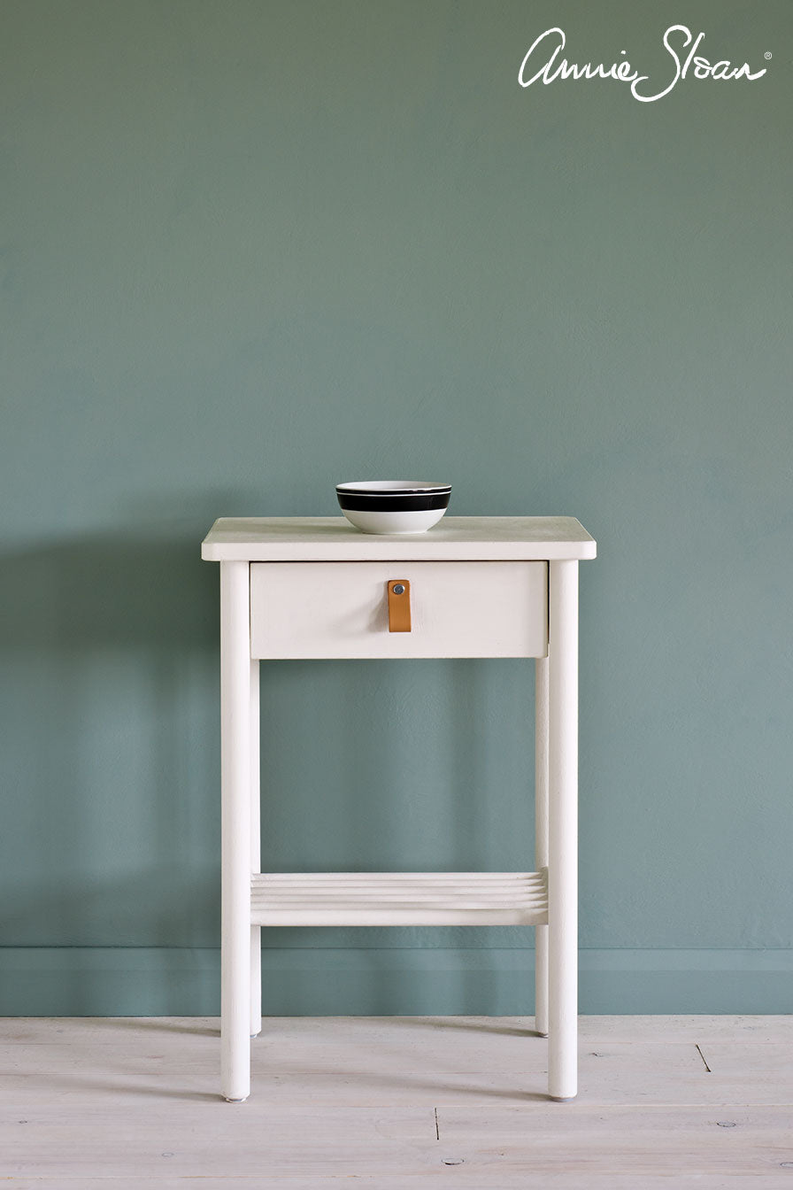 Small side table painted with Annie Sloan Old White Chalk Paint against a wall painted with Duck Egg Blue Wall Paint
